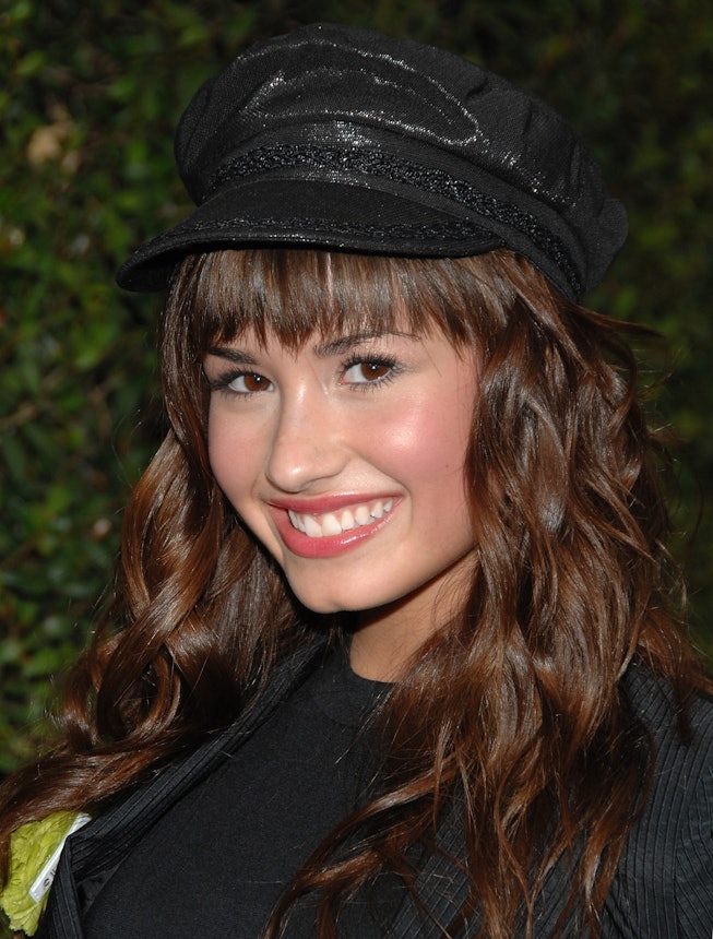Demi Lovato in 2008, wearing a black cap over top wavy brown hair