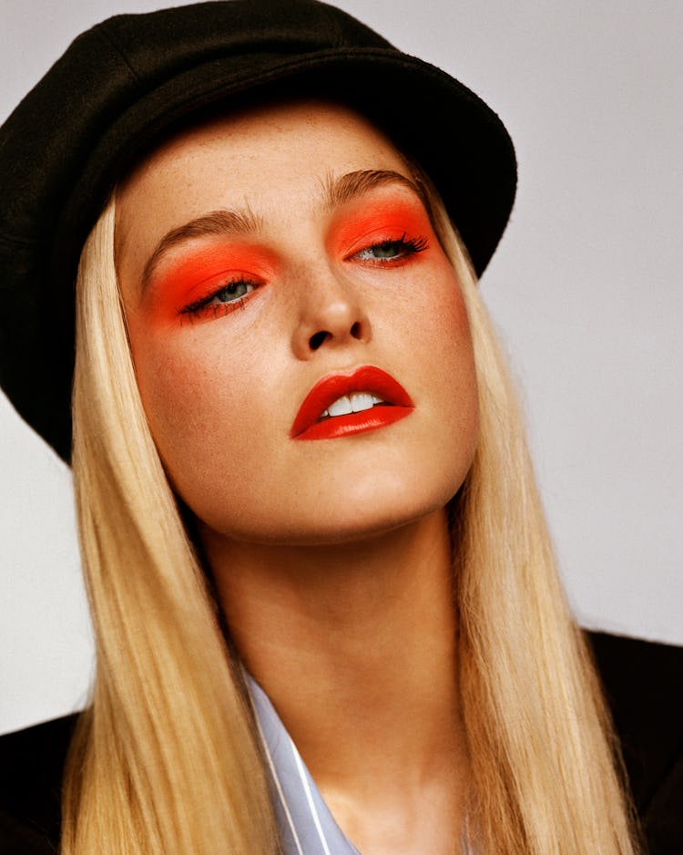 Jean Campbell in a black beret and a black jacket, with red eyeshadow 