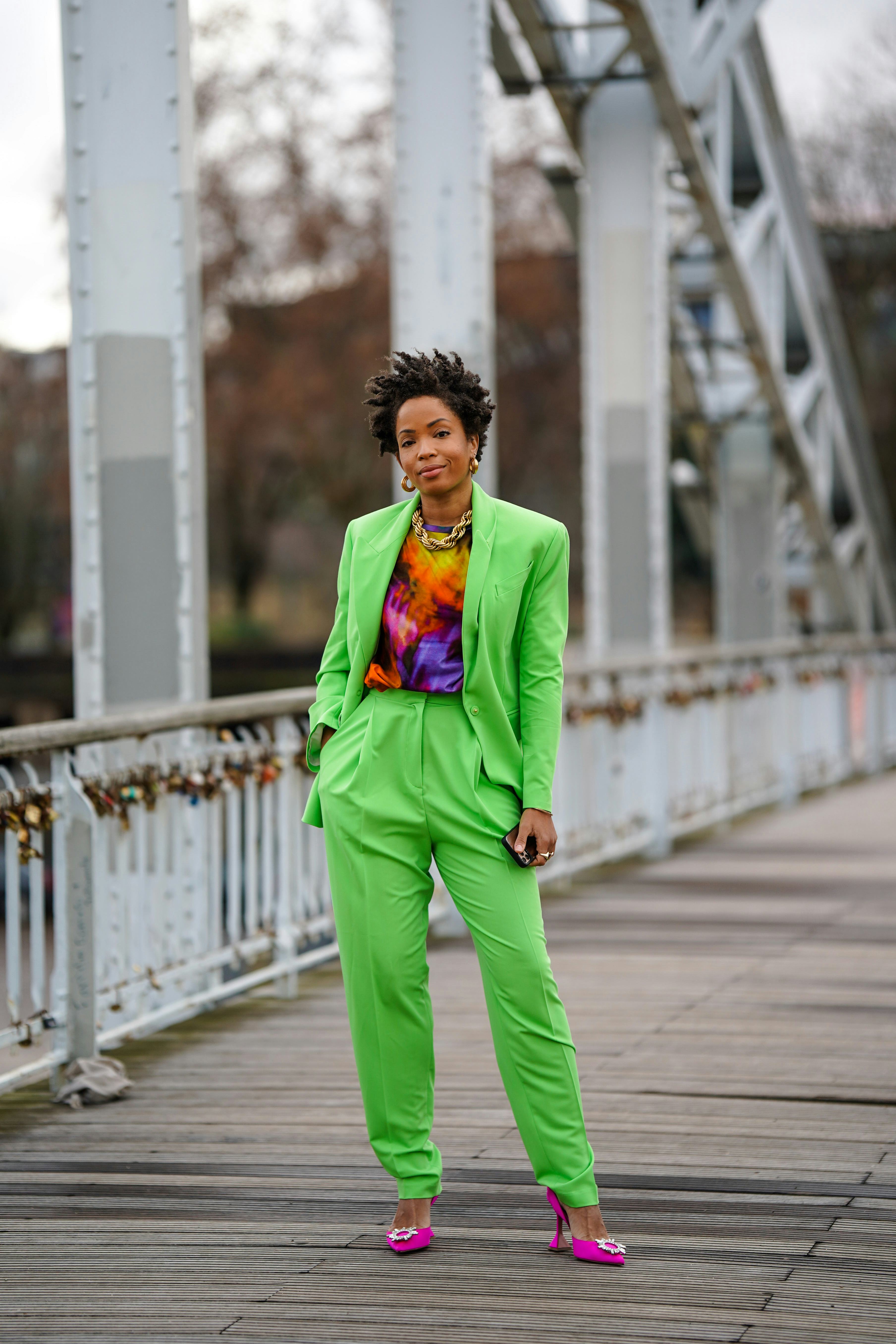 PARIS, FRANCE - JANUARY 28: Ellie Delphine wears golden earrings, a golden chain necklace, a purple ...