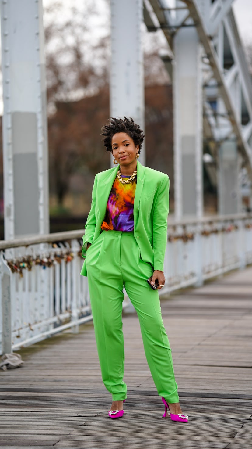 PARIS, FRANCE - JANUARY 28: Ellie Delphine wears golden earrings, a golden chain necklace, a purple ...