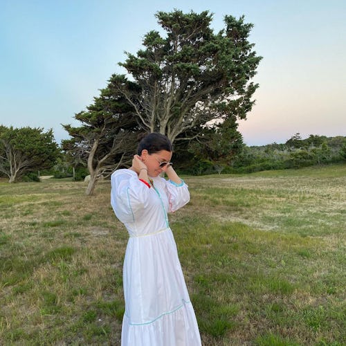 A woman posing in a long white linen affordable dress for Summer