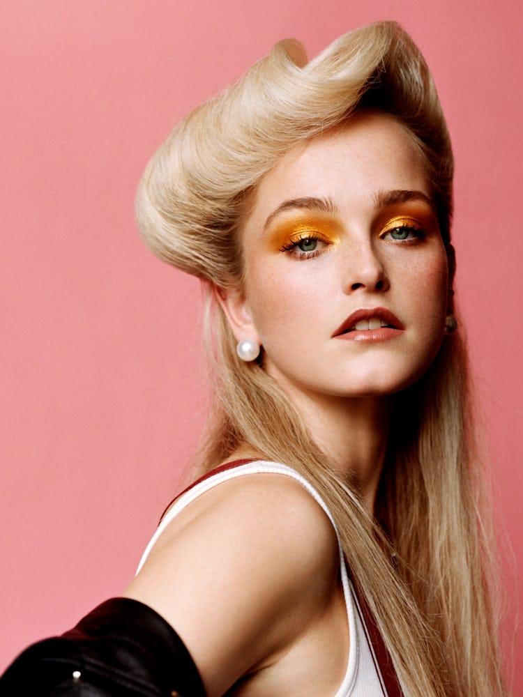 Jean Campbell in a white tank top, pearl earrings and orange eyeshadow 
