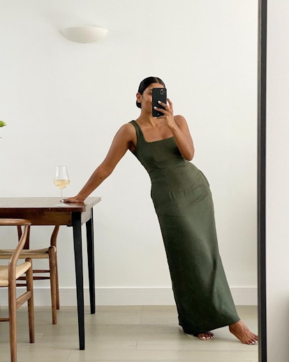 A woman taking a mirror selfie in a long khaki affordable dress for Summer