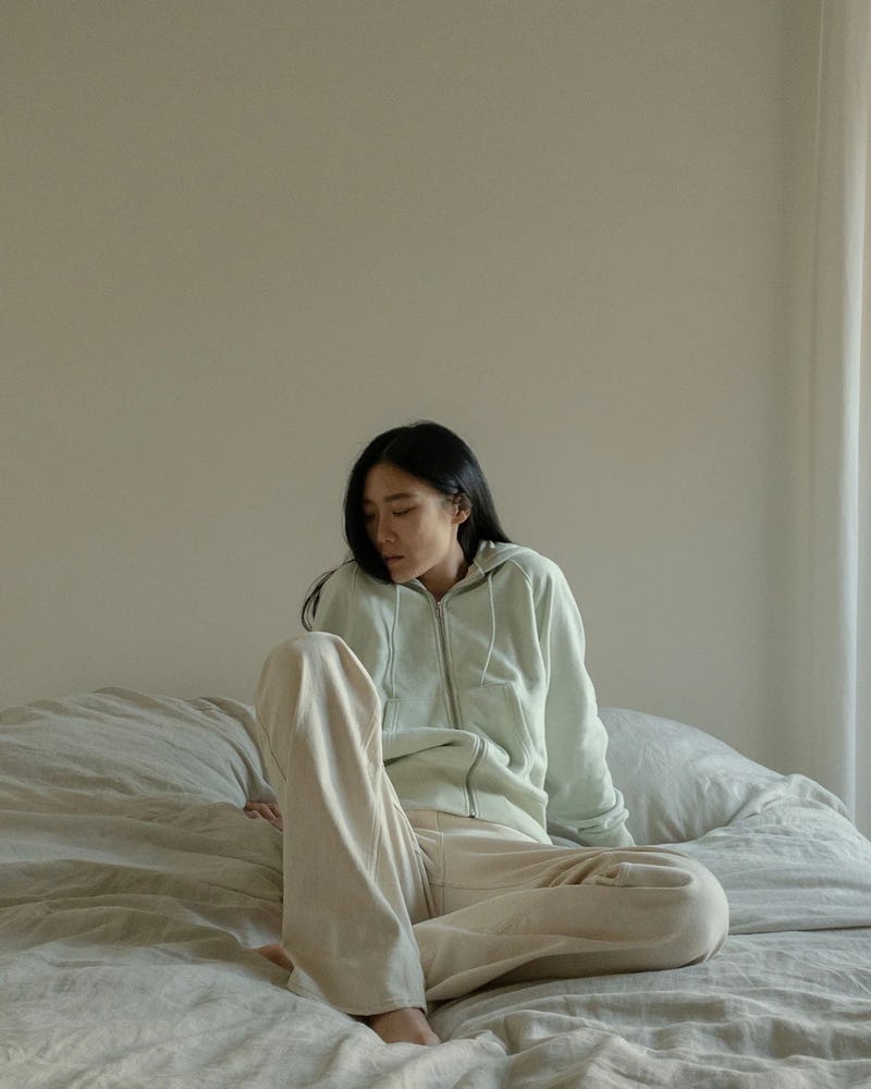 A model lying in bed wearing Thakoon sweats