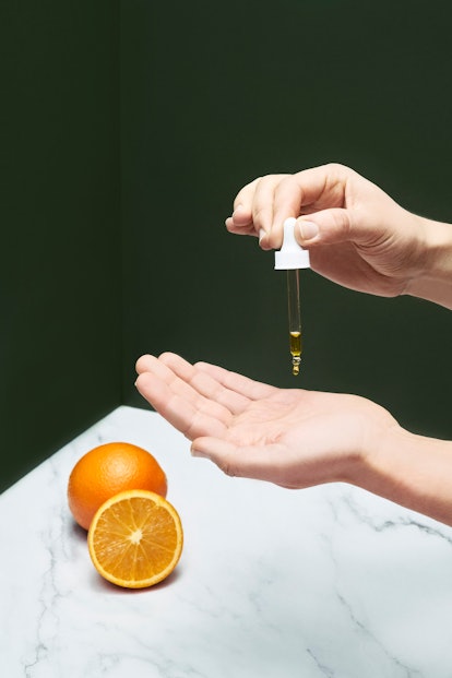 A woman applying an over-the-counter retinoids serum on the palm of her hand 