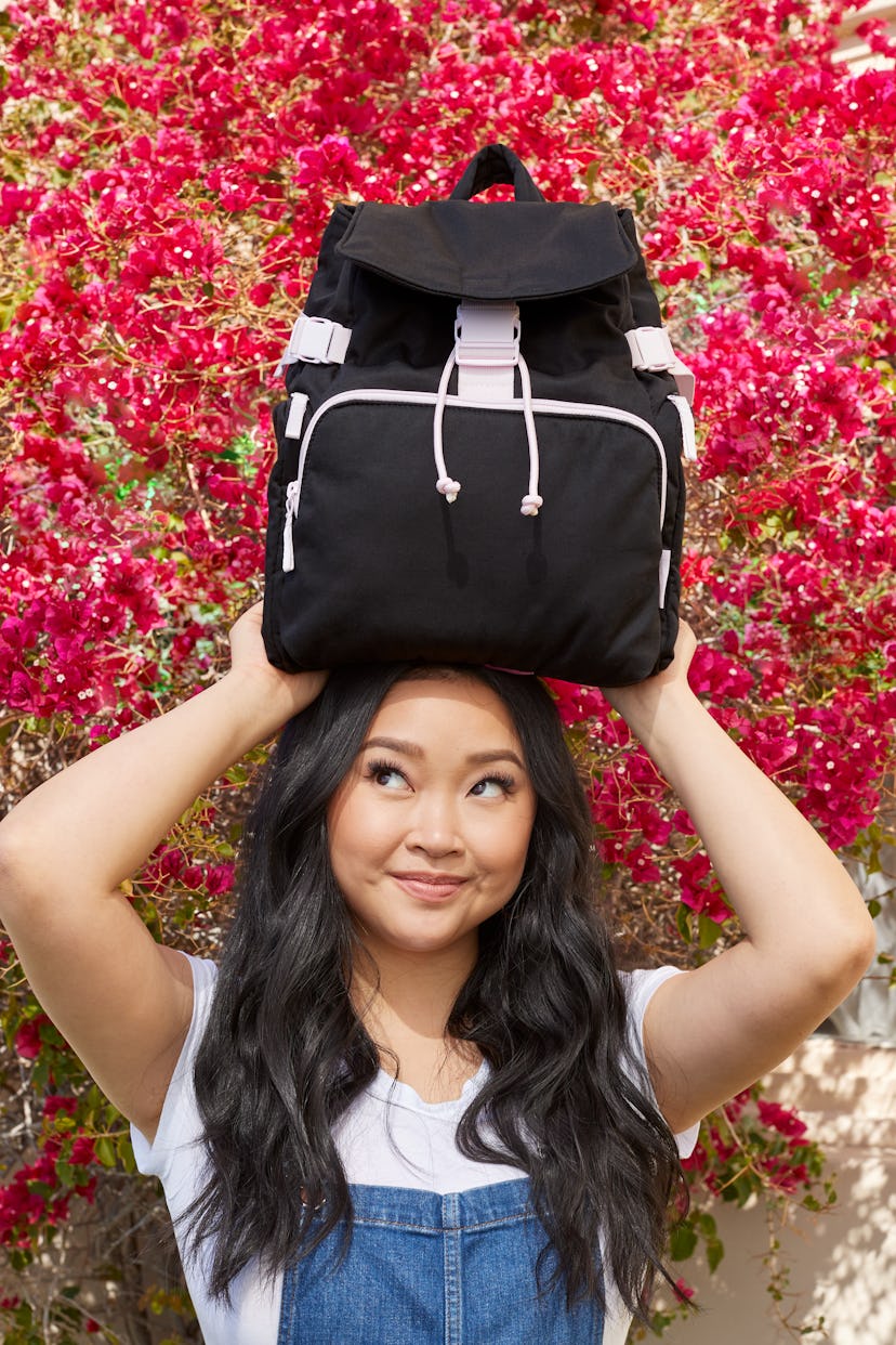 Holding a backpack above her head, the Lana Condor x Vera Bradley Recycled Cotton collection