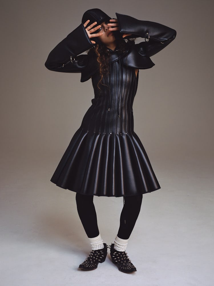 Model Deba Hekmat wears a Robert Wun hoodie, dress, and hat; Comme des Garçons tights; Gucci socks; ...