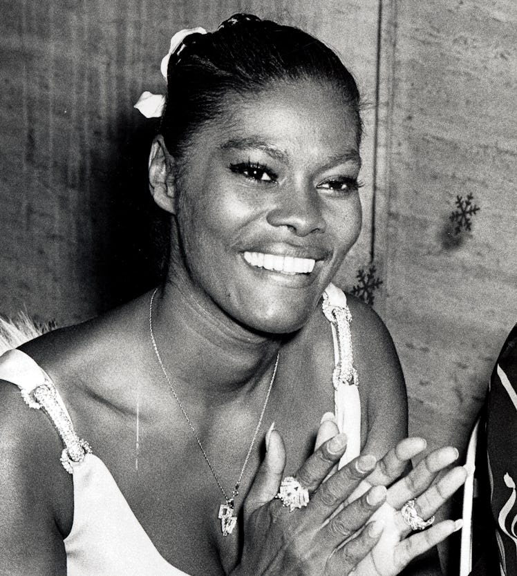 Dionne Warwick clapping and smiling with her hair up in a ponytail and white dress at the Grammy Awa...