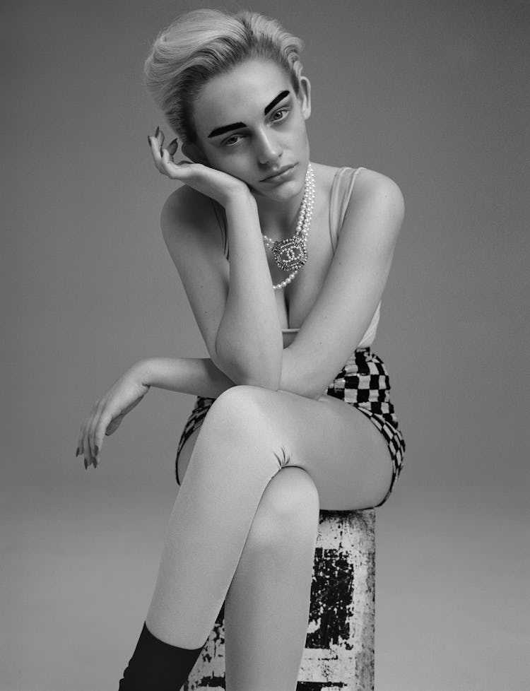 Model Misty Kyd wears a Chanel tank top, skirt, leggings, and necklace; Falke socks.