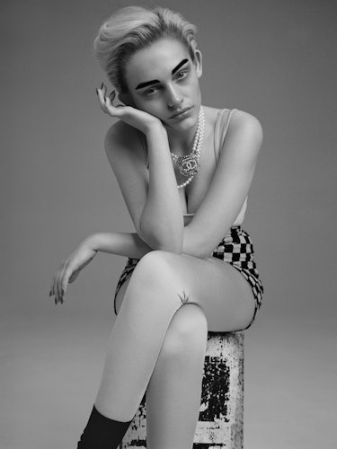 Model Misty Kyd wears a Chanel tank top, skirt, leggings, and necklace; Falke socks.