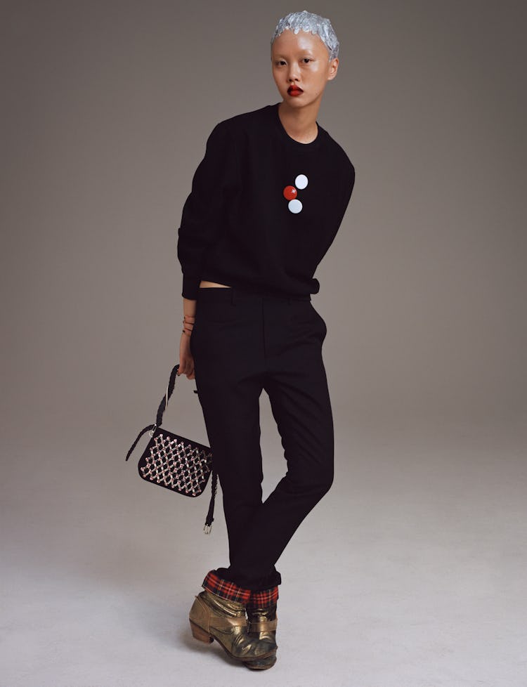 Model Jan Baiboon wears a Stefan Cooke sweater and pants; Miu Miu bag; vintage Junya Watanabe boots.