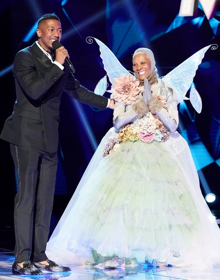 Dionne Warwick on Masked Singer in a Fairy costume, standing next to Nick Cannon 
