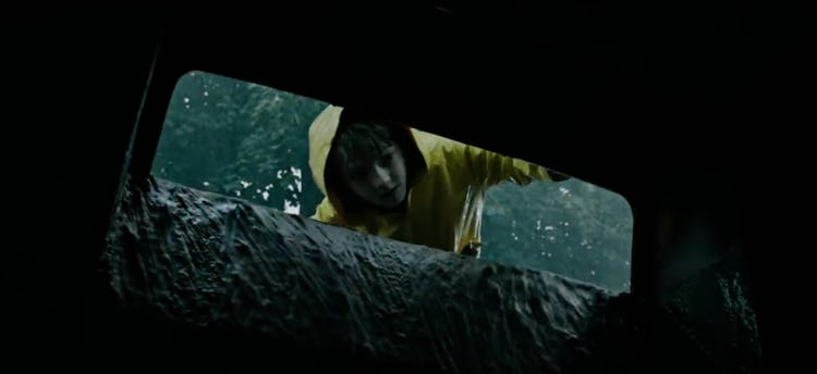 kid looking into gutter in yellow raincoat 