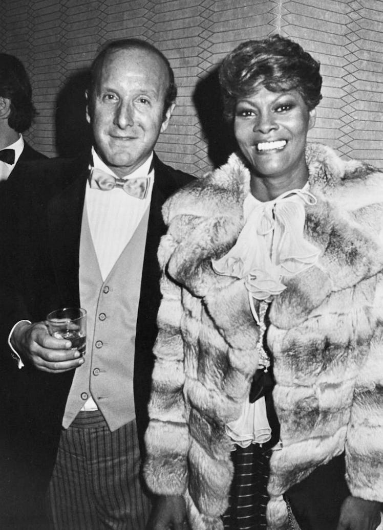 Dionne Warwick in a fur coat and white shirt, and Clive Davis in a tuxedo posing for a photo