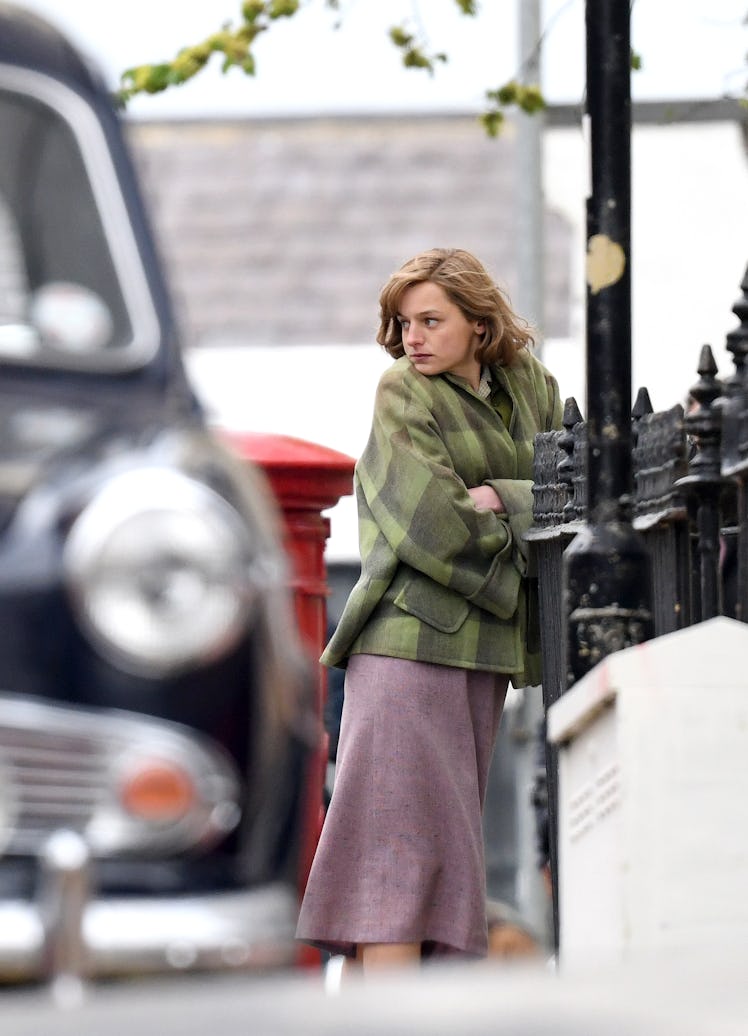 Emma Corrin wearing a green coat