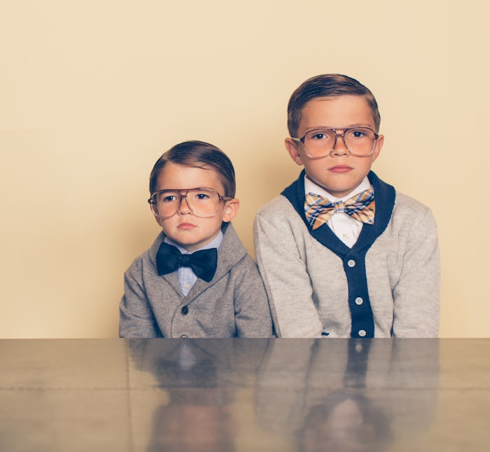 two young brothers wearing retro glasses, cardigans, and bowties for national brothers' day