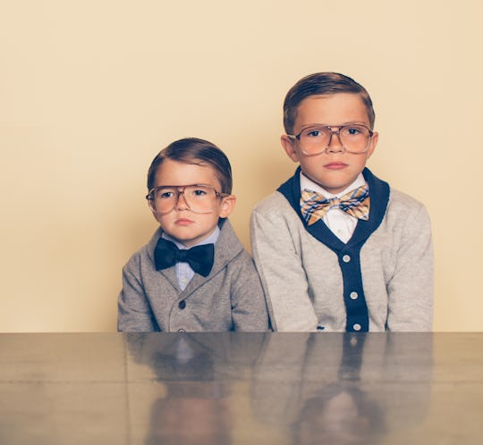 two young brothers wearing retro glasses, cardigans, and bowties for national brothers' day