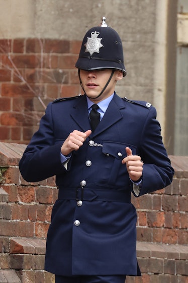 Harry Styles dressed as a cop and running