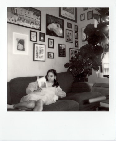 Michelle Zauner laying on the couch reading a book.