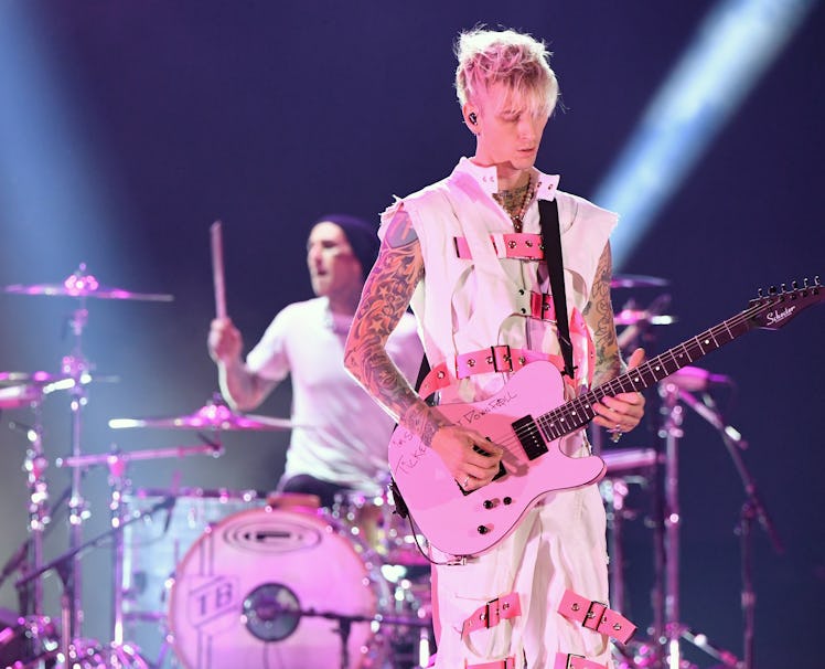 Travis Barker and Machine Gun Kelly performing onstage for the 2020 American Music Awards, dressed i...