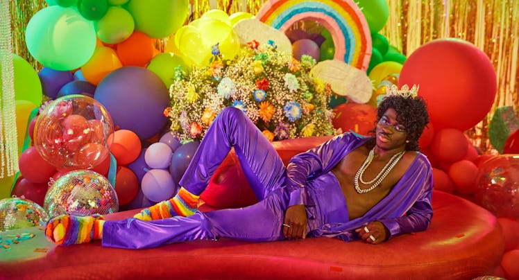 lil nas x reclining in a purple outfit