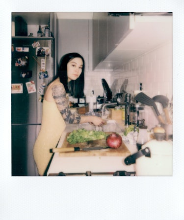 Michelle Zauner in the kitchen cutting lettuce.