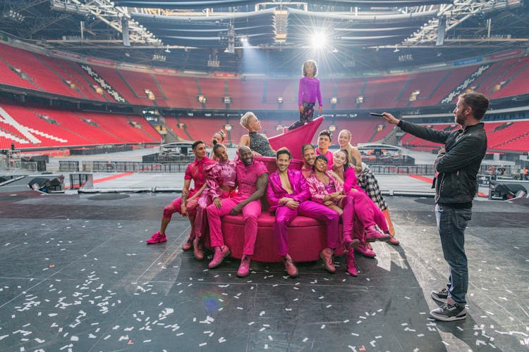 Pink surrounded by performers on a couch with her daughter standing on top 