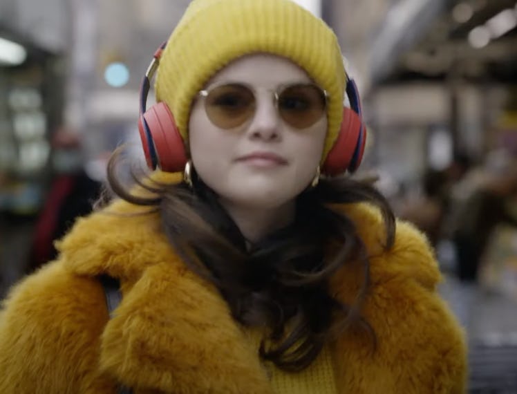 Selena Gomez wearing a yellow beanie and teddy coat