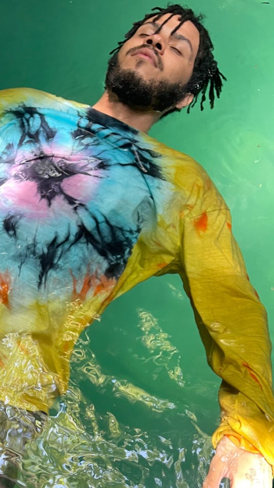 A model in water in a tie dye multi-colored sweatshirt by designer Esper for the brand Come Back As ...