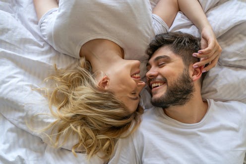 A man and woman in bed together, side by side