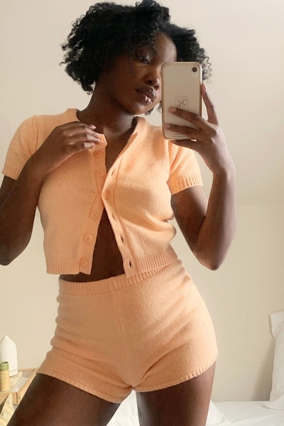 Woman taking a selfie in a peach colored short set