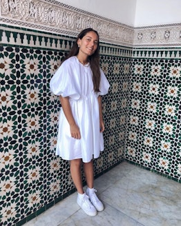 Victoria Saceanu wears a white midi summer dress paired with white sneakers.
