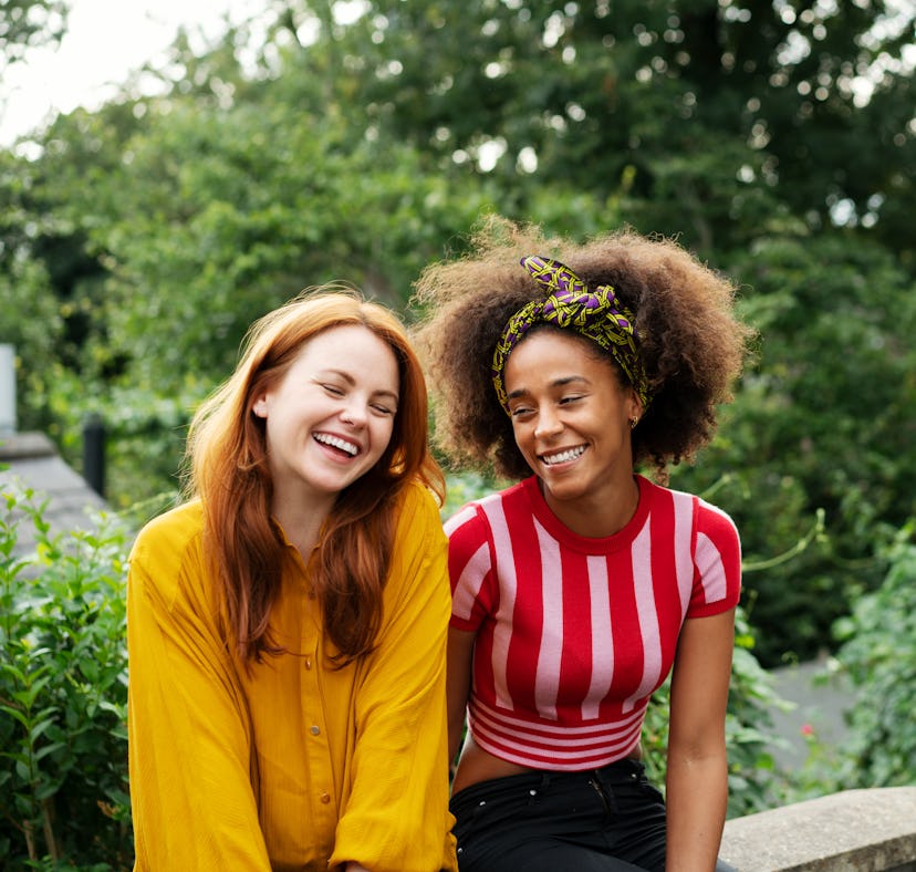 Two happy young friends reaping the benefits of their May 24, weekly horoscope.