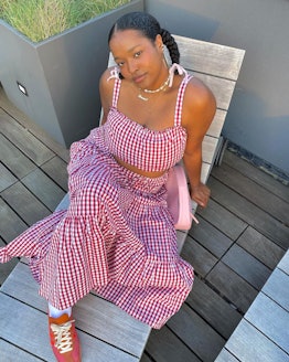 Imani Randolph wears a floaty gingham dress paired with brick-red sneakers.