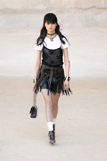 model in Chanel fringe skirt white tee and black tank top