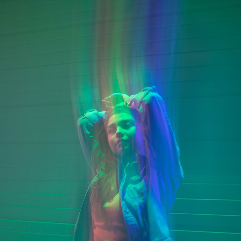 Young woman illuminated by a rainbow of colors during the May 2021 full blood moon.