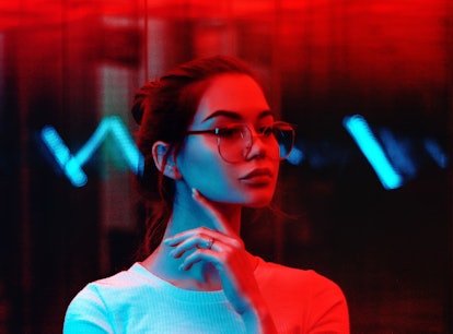 Young woman in red neon light during the May 2021 blood moon.