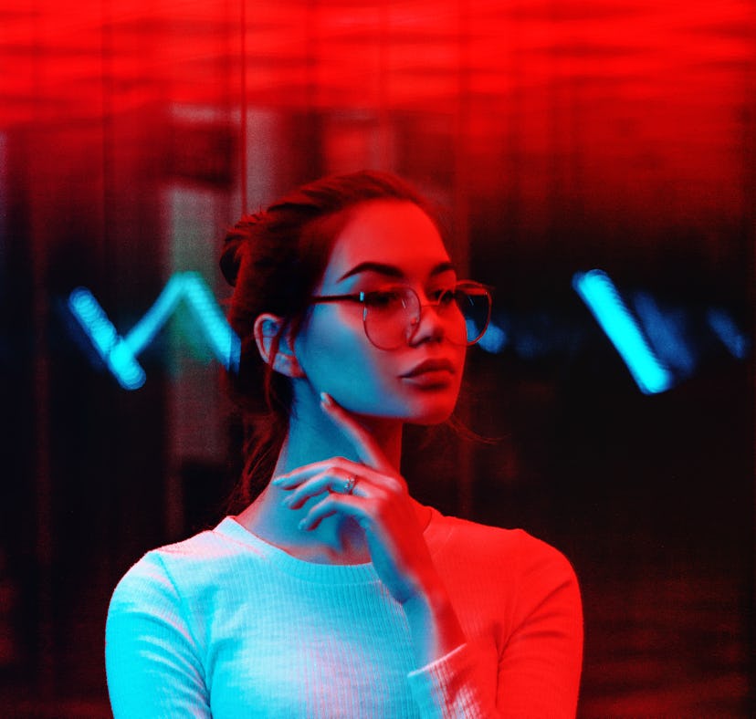 Young woman in red neon light during the May 2021 blood moon.