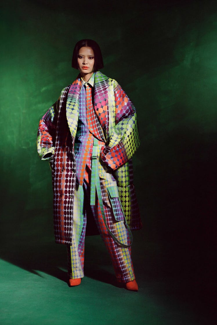 Model posing while wearing a colorful coat and a matching set