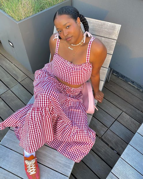 Imani Randolph wears a floaty gingham dress paired with brick-red sneakers.