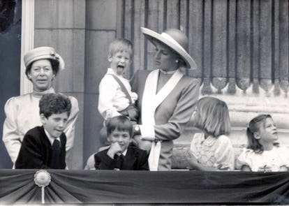 Prince Harry in Princess Diana's arms, sticking his tongue out while Willam chuckles