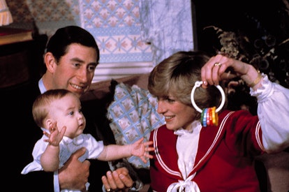 Baby Prince WIlliam in Father, Prince Charles' lap, Princess diana holding a baby toy
