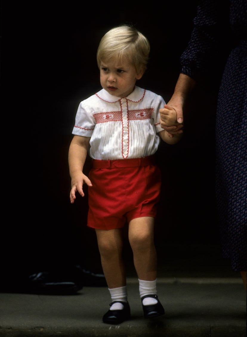 Young prince william in white button down and red shorts