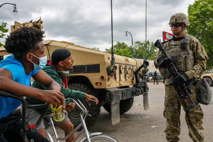 A Minnesota National Guard soldier and two protesters on bicycles in Minneapolis