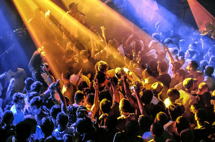 A large crowd of people with blue and yellow lights before Covid-19