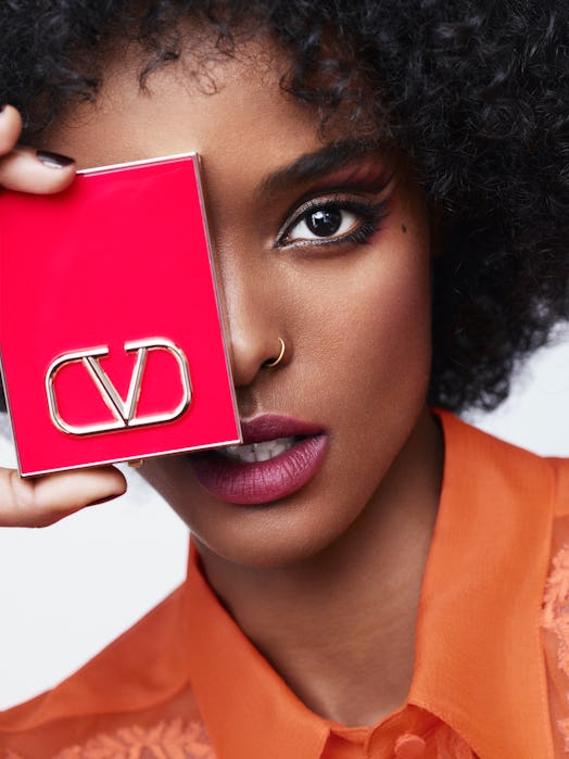 Model in Valentino makeup holding compact