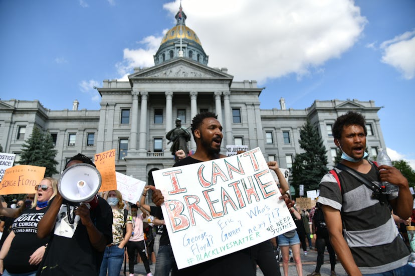 Protesters outside the Colorado State Capitol with signs that say "I can't breathe"
