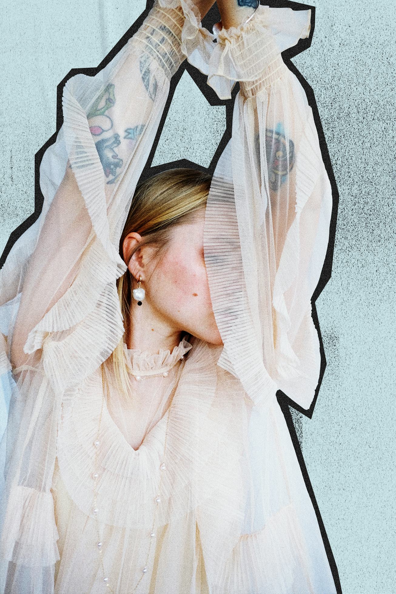 A blonde woman wearing a sheer white silk chiffon vintage wedding dress