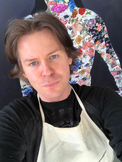 A selfie of Christopher Kane in a black shirt and a beige apron 
