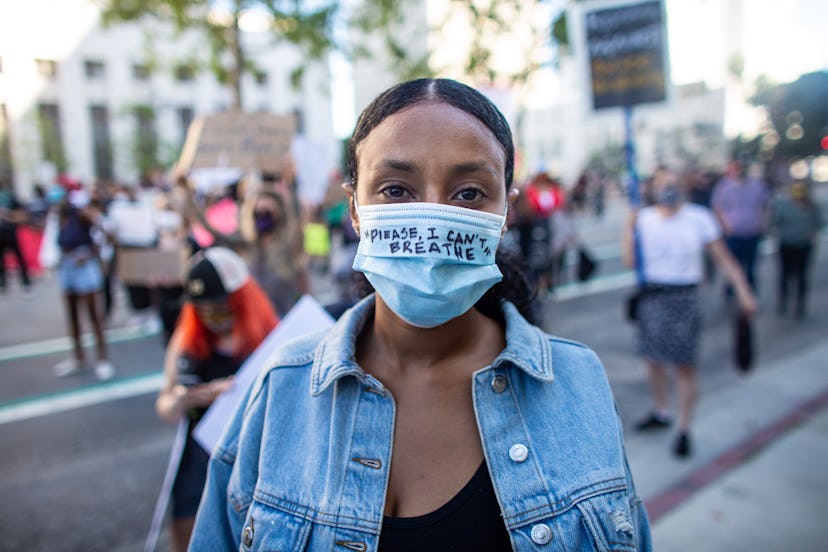 Harina Yacob protesting in downtown Los Angeles with a mask that says "please, I can't breathe"